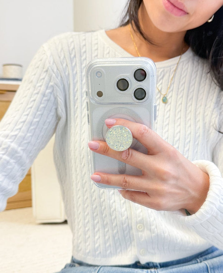 Person holding a phone with a glittery Suction Mini-Grip in a casual setting