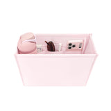 A light pink fabric organizer bin with multiple interior compartments, shown on a white background and filled with sample items including a matching pink bottle, sunglasses, a phone case, and small accessories.
#color_ballet pink bow
