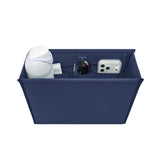 A navy blue fabric organizer bin with multiple compartments, shown holding various items including a white bottle, a small jar, sunglasses, and a smartphone case, on a solid white background.
#color_oxford navy
