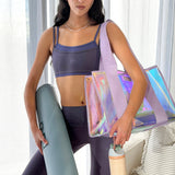 Woman holding a yoga mat and a colorful bag in a bright room