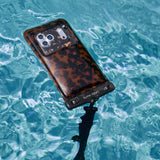 Phone with tortoiseshell waterproof floating pouch submerged in water #color_tortoiseshell