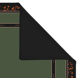 A folded black mat or rug shown on a white background, with part of the patterned reverse side visible. The visible pattern includes dark brown bands with small orange motifs and some light text.
#color_classic tortoiseshell
