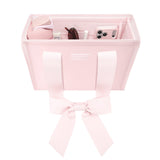 A light pink fabric organizer tote bag with two handles and a bow, shown open with various small accessories inside on a white background.
#color_ballet pink bow