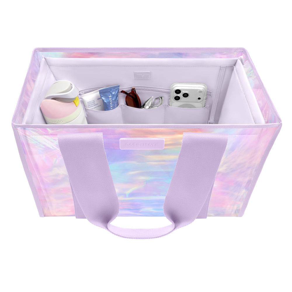 A pastel iridescent storage organizer bag with lavender handles, shown open on a white background. The bag has multiple interior compartments containing toiletry items and a phone, with a small front label
#color_lavender