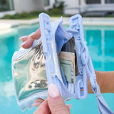 Hand holding a transparent pouch with money and cards by a pool #color_mist twinkle