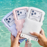 Three phone cases held by hands with a blurred water background #color_ivory twinkle