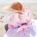 @bobbiefathh image of bow tote on the beach on a pink and white striped towel with a straw hat peaking out. #color_ballet pink bow