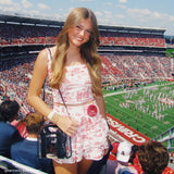 Woman in a floral dress at a football stadium with a large crowd and field. #color_midnight_black