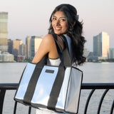 A woman showing her Silver chrome Jelly Tote Bag with City Skyline behind her
#color_silver chrome