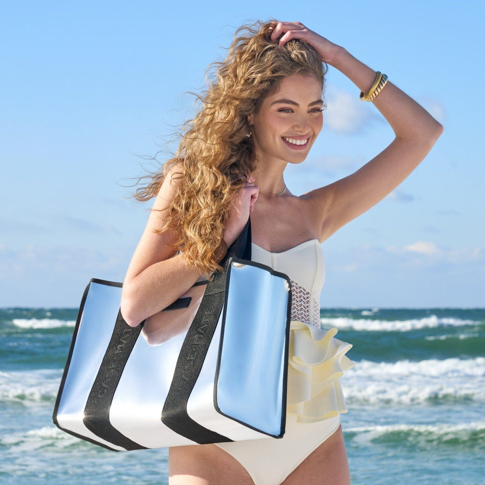 Woman holding a reflective beach bag with ocean and sky in the background
#color_silver chrome