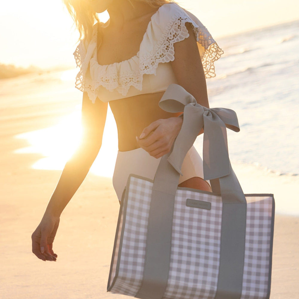Woman holding a gingham tote bag on a beach at sunset
#color_latte gingham bow