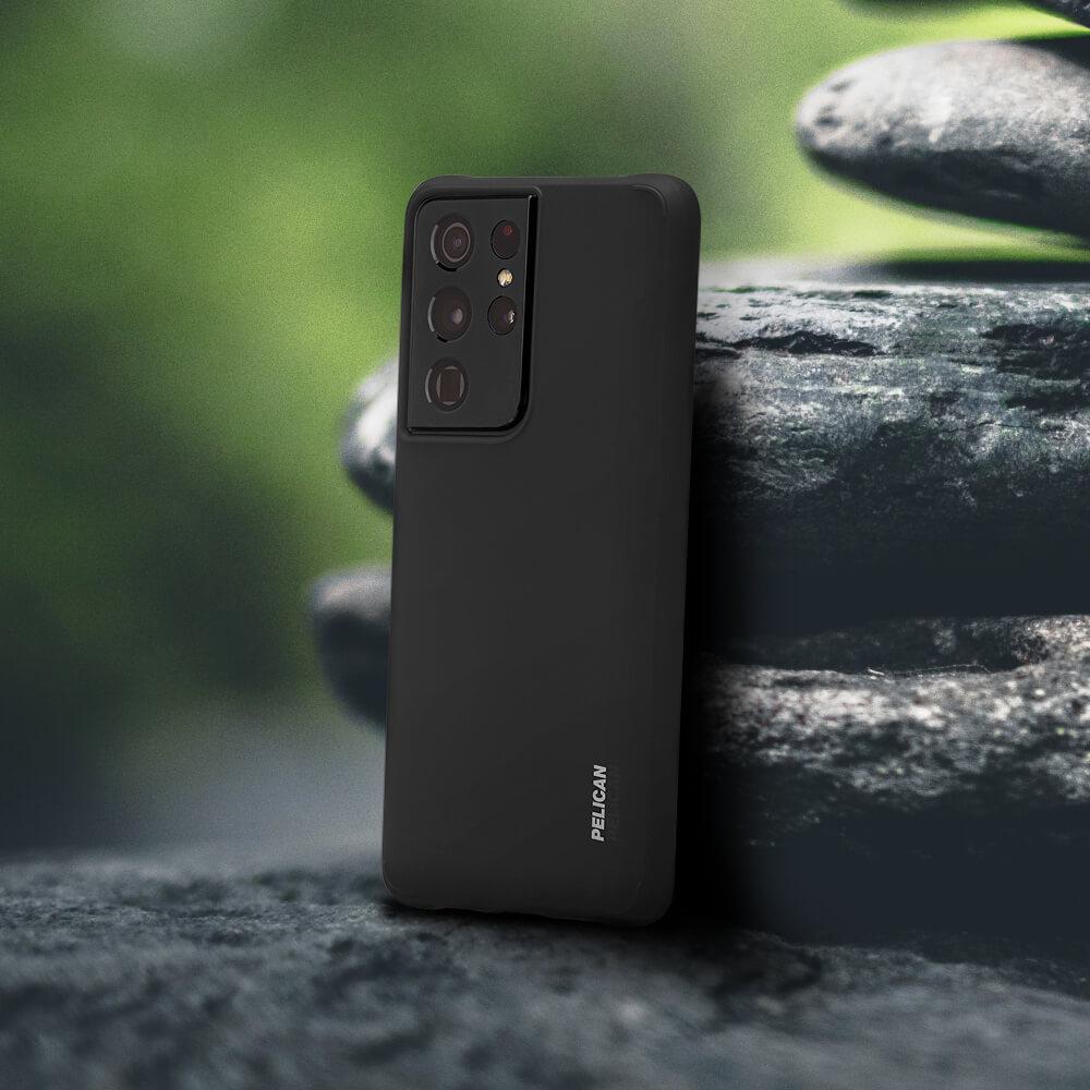 Black Pelican Adventurer leaning against a rock. color::Black