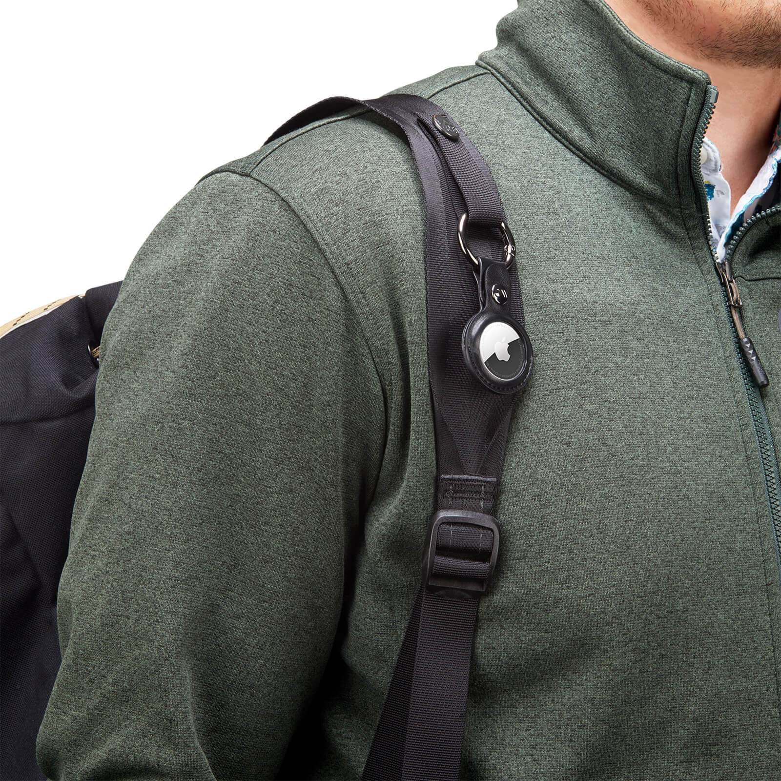 AirTag Keychain Case clipped onto arm of backpack. color::Black