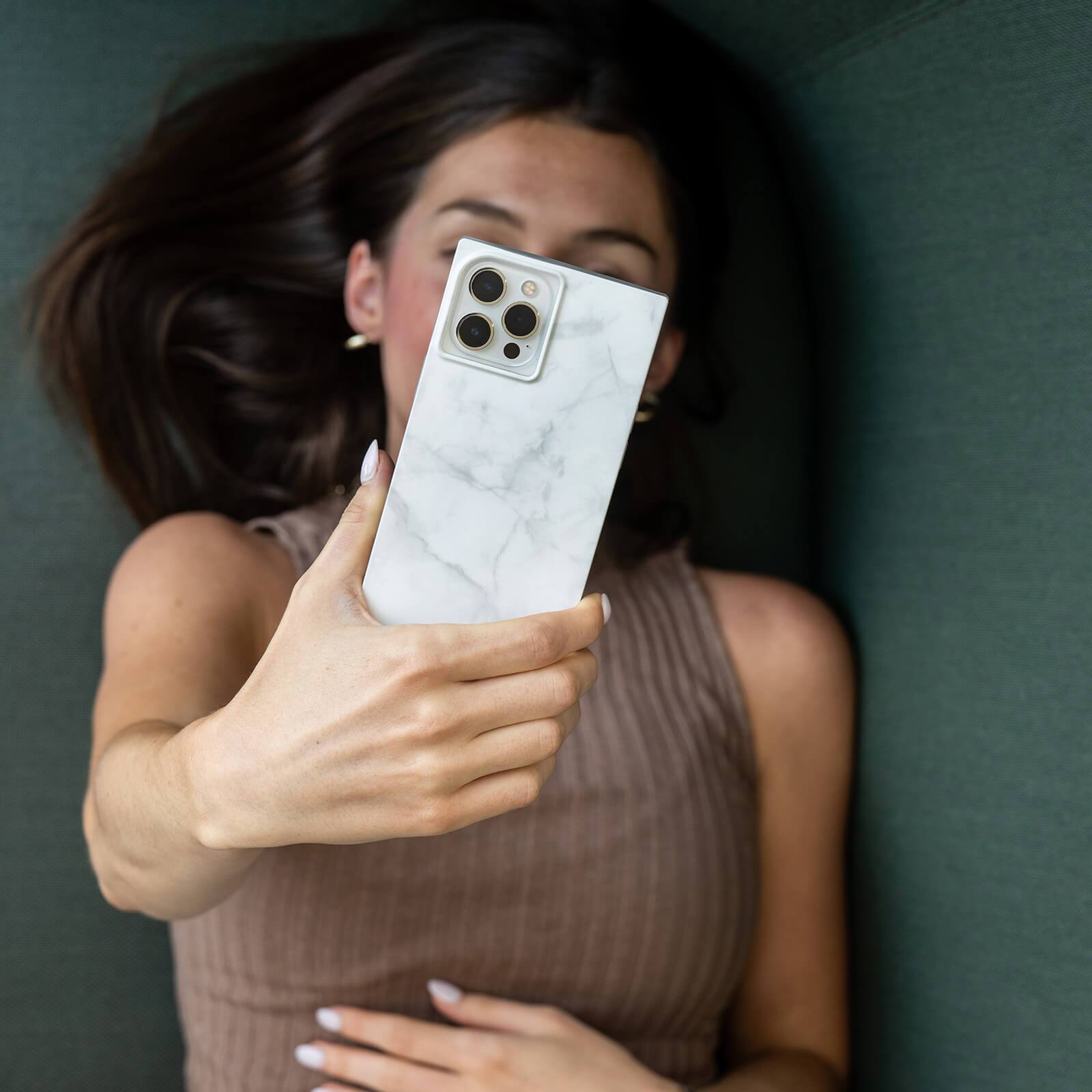 Woman holding white marble print square case. color::White Marble