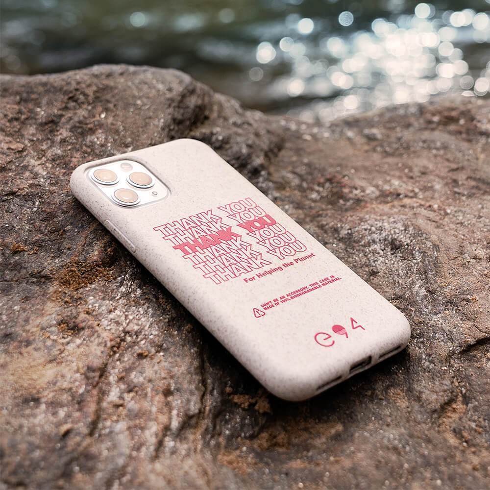 Biodegradable iPhone 11 Pro case sitting on rock by river. color::Thank You