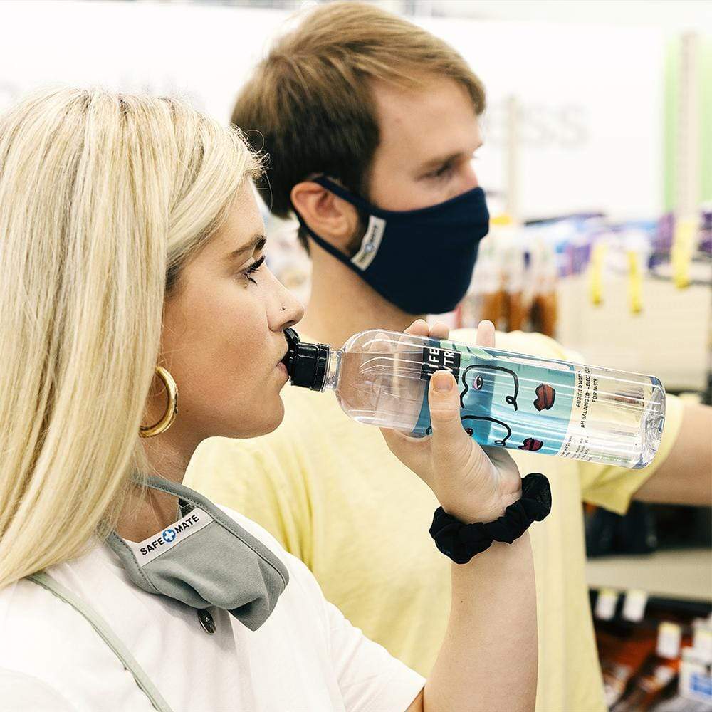 Man wearing navy cloth mask and woman wearing gray cloth mask around her neck while drinking water. color::Multicolor
