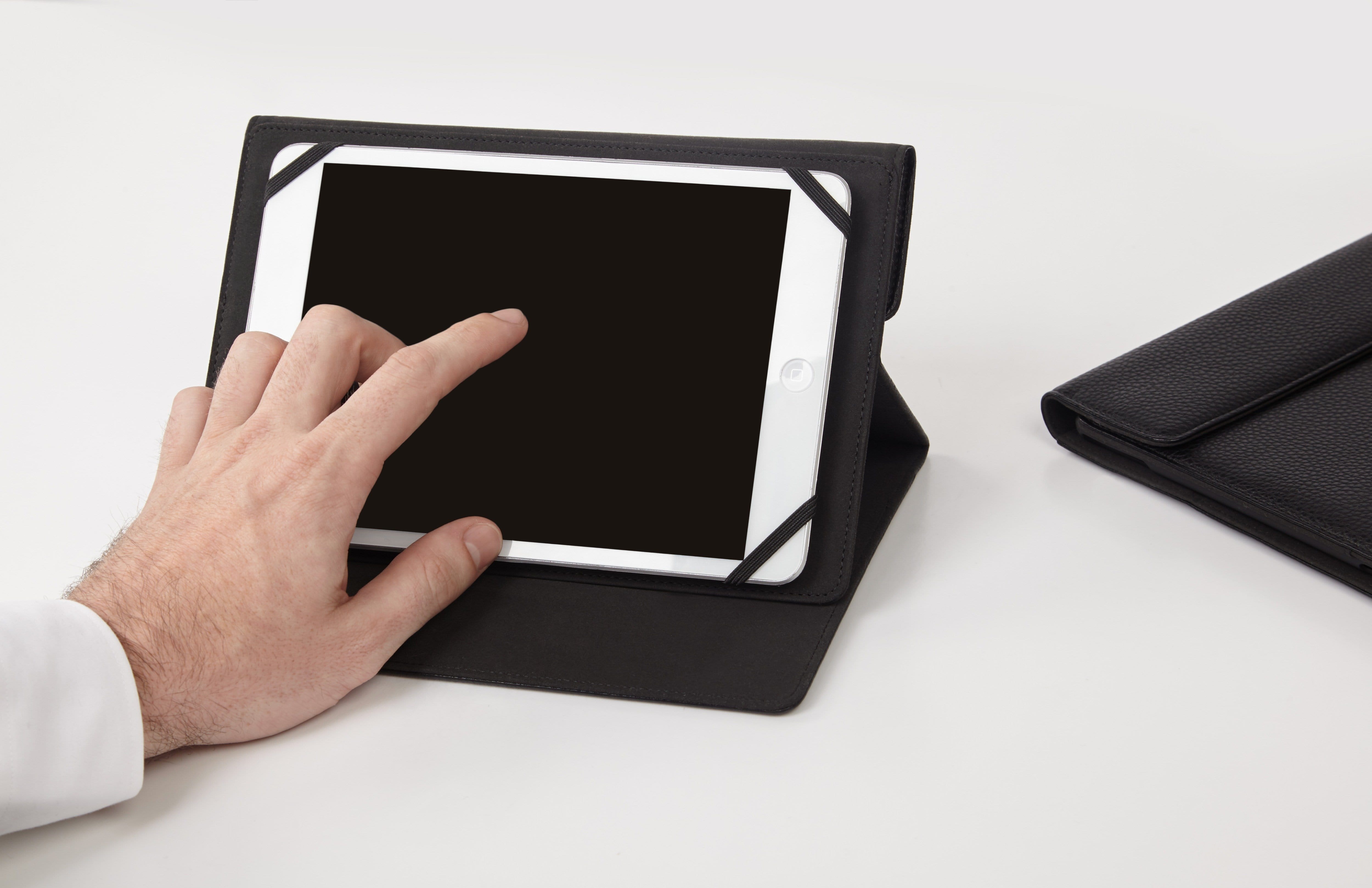 Hand touching screen of tablet. color::Black