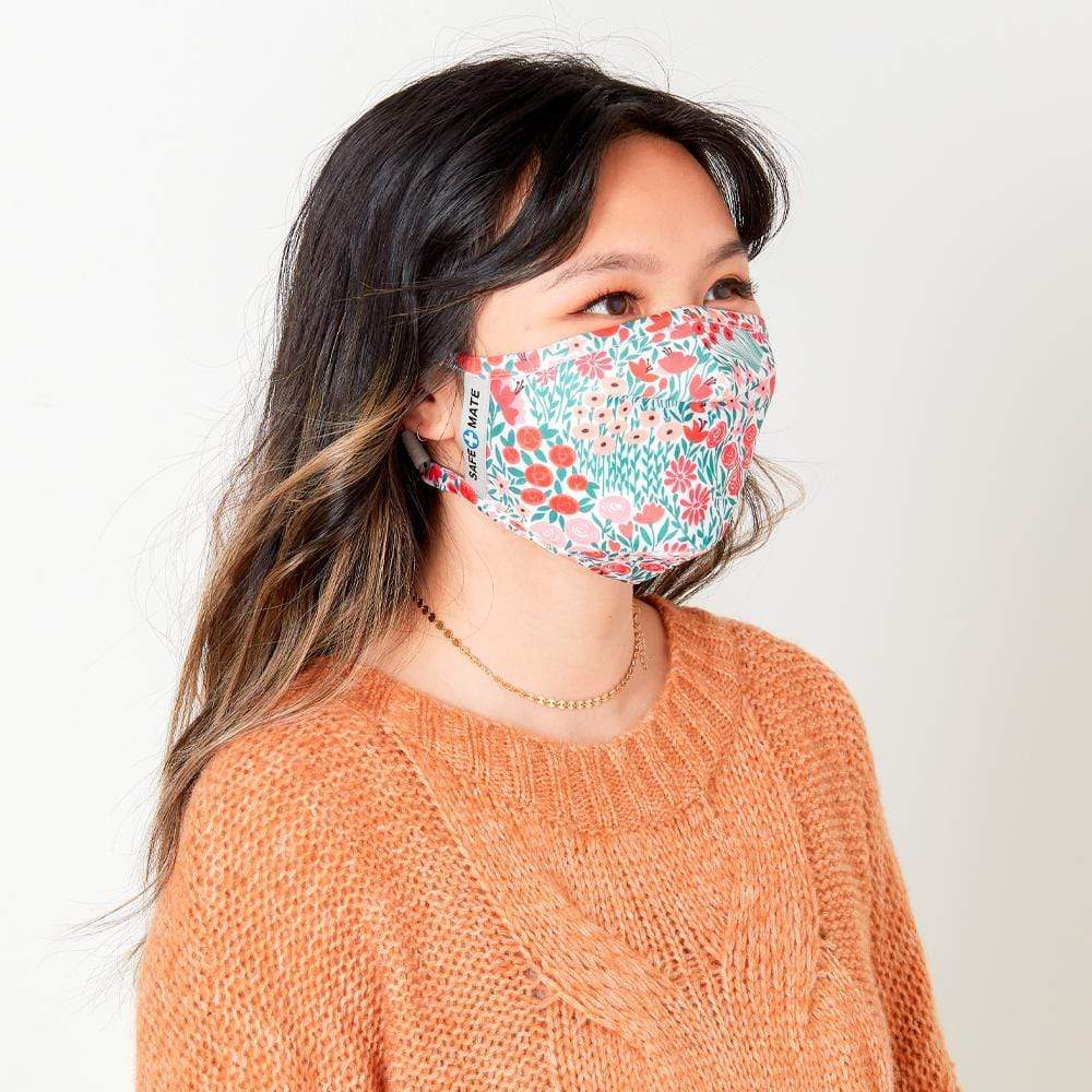 Woman wearing fashion floral face mask. color::Warm Meadow