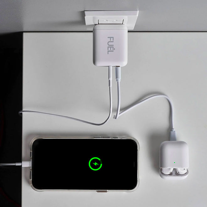 a dual port wall charger charging a phone and wireless earphones