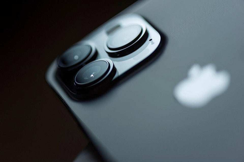 How do I take care of my iPhone 13 camera lens?