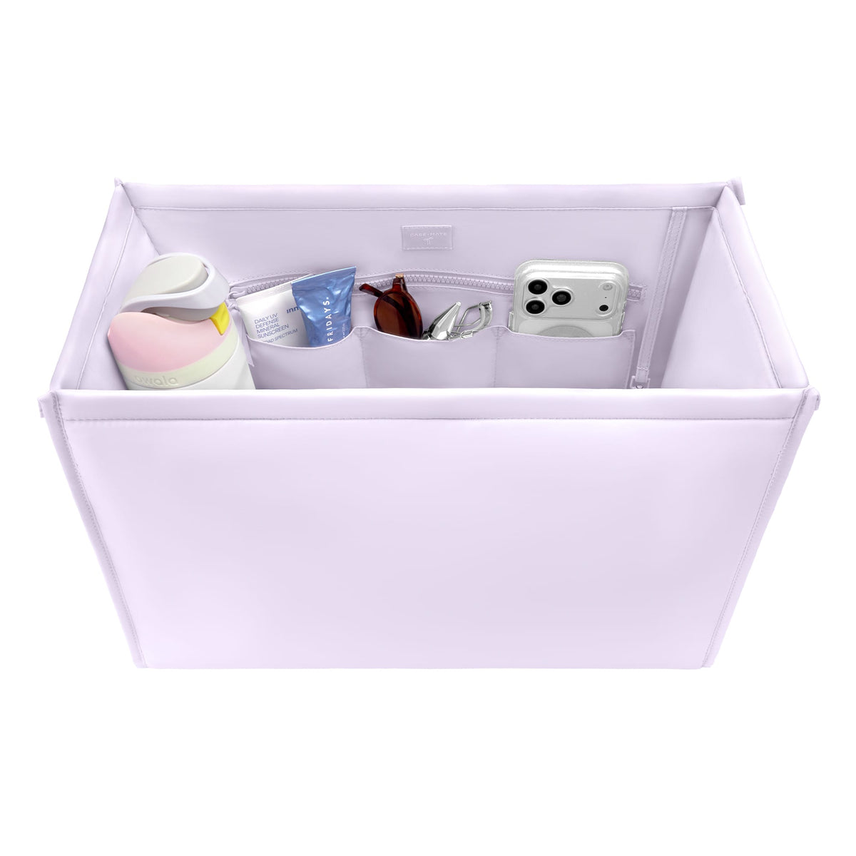 A light lavender fabric organizer box with multiple interior pockets, shown on a white background and filled with various small accessories like a bottle, sunglasses, and a phone case.
#color_lavender 