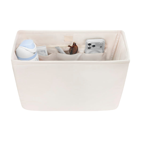 Beige fabric organizer with compartments containing various items on a white background #color_french vanilla