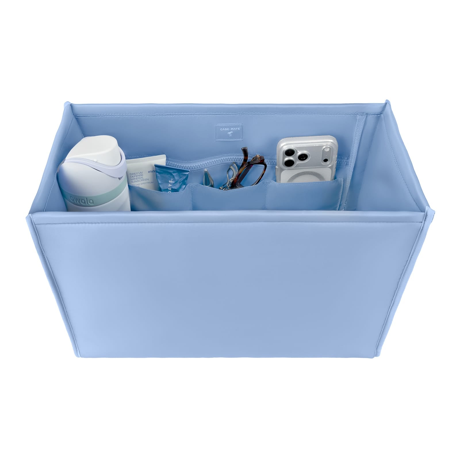 A light blue fabric organizer box with multiple interior pockets, shown on a white background and filled with assorted small items including a white bottle, a tube, glasses, and a white camera.

#color_carolina blue