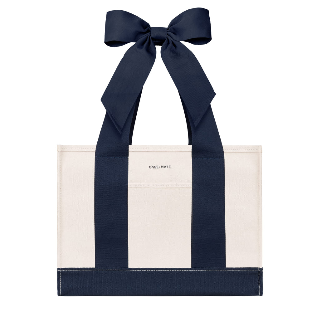 An off-white canvas tote bag with bold navy blue vertical stripes and matching navy ribbon handles tied in a large bow at the top. The brand name 'CASE-MATE' is printed in small black letters on the front pocket.
#color_oxford navy bow