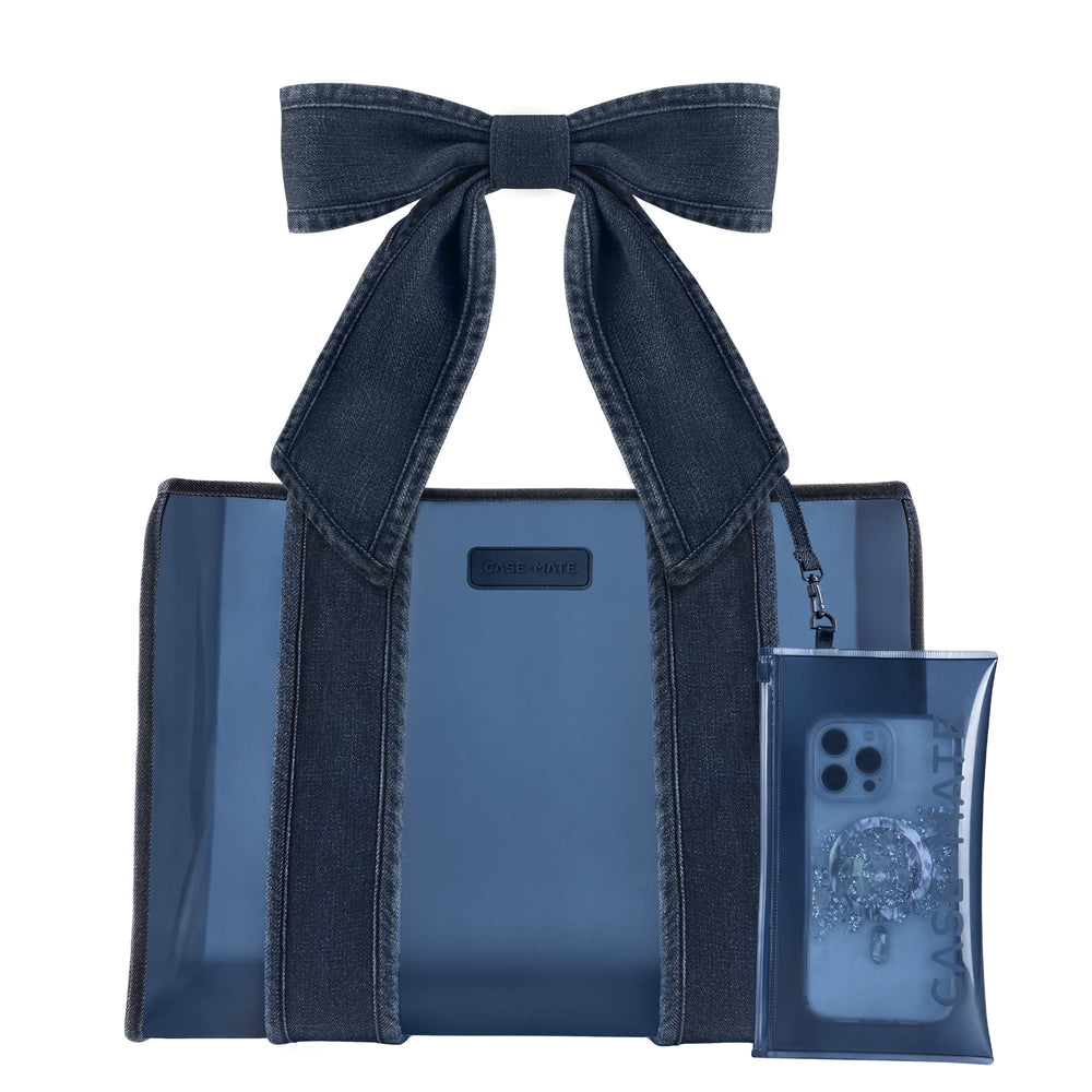 A dark blue denim strap jelly tote bag with matching denim shoulder straps and a large bow, shown alongside a matching translucent phone pouch on a plain white background.
#color_dark wash denim bow