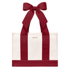 A red and white tote bag with wide pink shoulder straps and a large matching pink bow at the top, shown on a plain white background

#color_cranberry bow