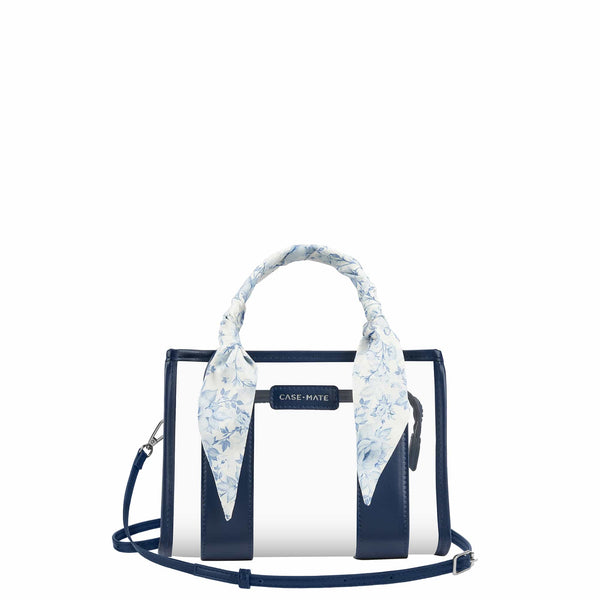 A Case-Mate structured handbag with navy blue and white vertical stripes, featuring a light blue and white floral silk scarf tied to the top handle, set against a plain white background.

#color_something navy twilly
