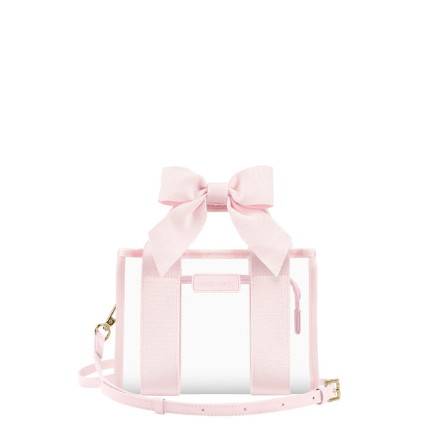 A light pink transparent tote bag with a large matching fabric bow on top, pink webbing handles, a thin shoulder strap, and small gold-tone hardware, shown on a plain white background.

#color_ballet pink bow