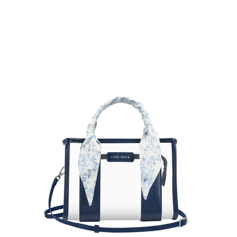 A Case-Mate structured handbag with navy blue and white vertical stripes, featuring a light blue and white floral silk scarf tied to the top handle, set against a plain white background.

#color_something navy twilly