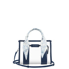A Case-Mate structured handbag with navy blue and white vertical stripes, featuring a light blue and white floral silk scarf tied to the top handle, set against a plain white background.

#color_something navy twilly