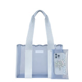 A light blue translucent tote bag with matching fabric shoulder straps, shown on a white background next to a clear phone case with a decorative pop-sack grip and the brand name CASE-MATE.

#color_carolina blue crochet wave