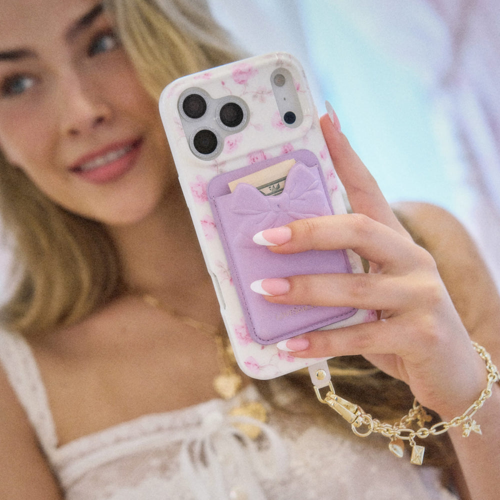 Person holding a phone with a floral case and purple card holder
#color_purple