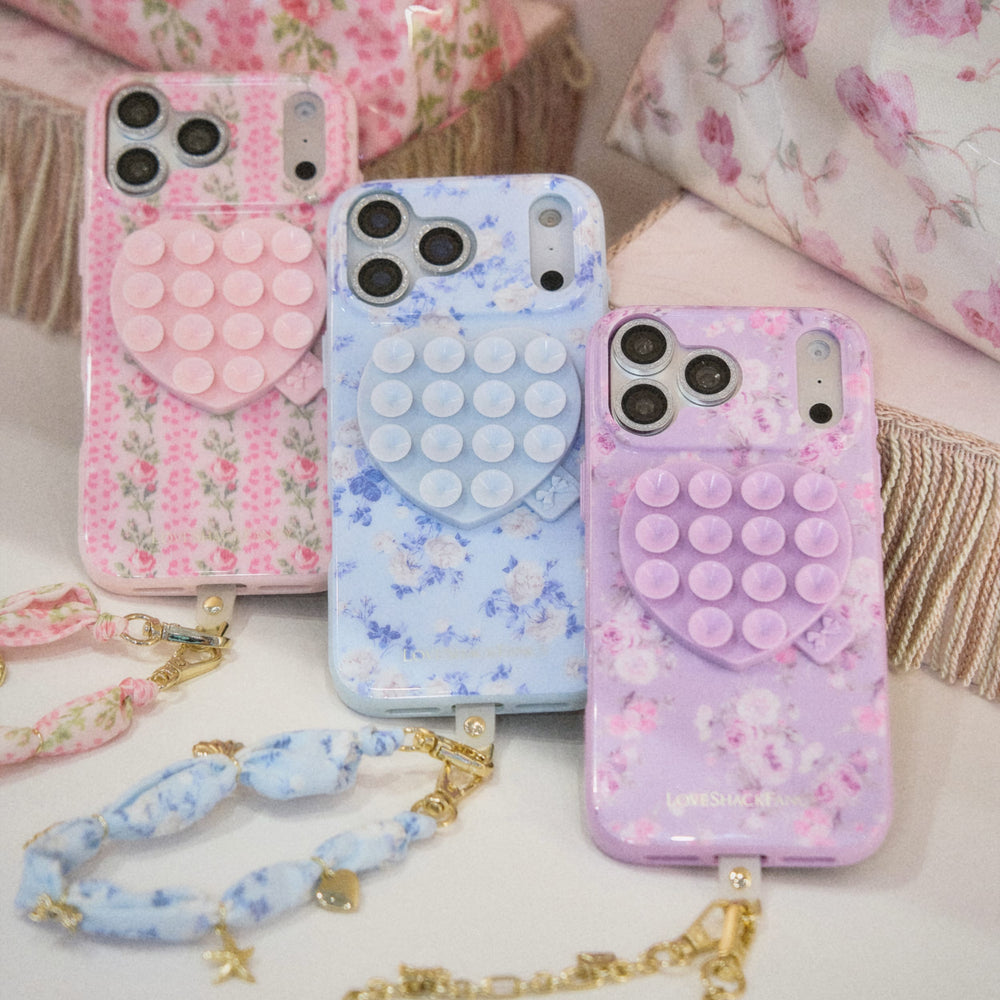 Three floral phone cases with a matching necklace on a soft surface.
#color_blue