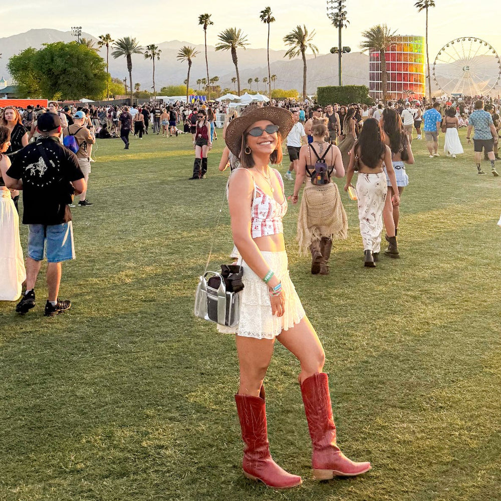 Woman in cowboy boots and hat at a music festival with palm trees and Ferris wheel in the background.

#color_silver chrome