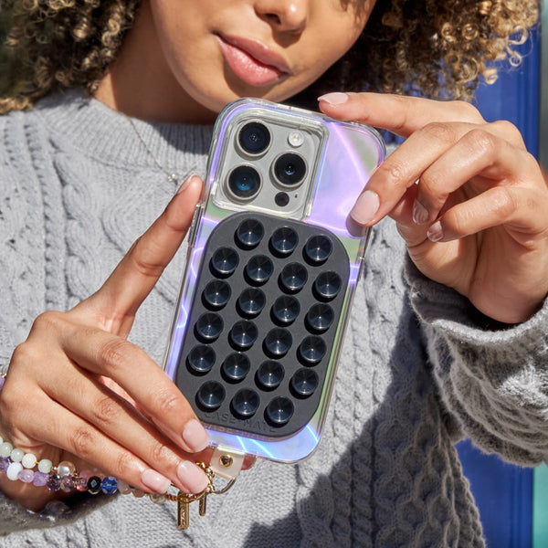 Person holding a phone with a unique case featuring black circular patterns.
#color_midnight black