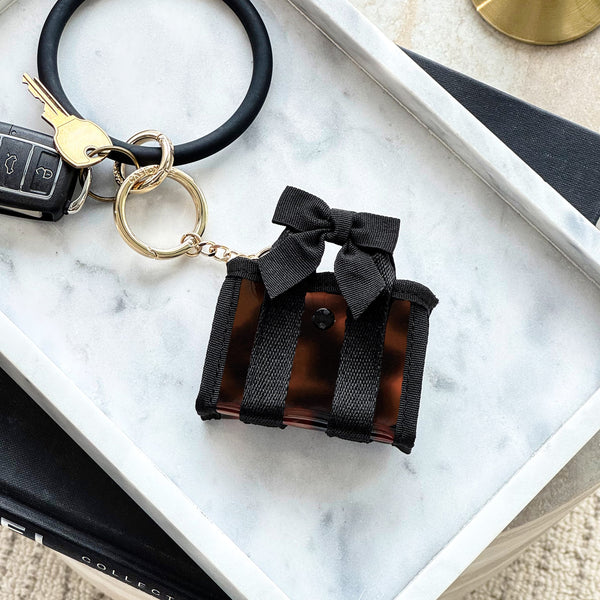 Black keychain with a bow on a marble surface
#color_tortoiseshell bow