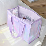 A lavender iridescent tote bag with matching shoulder straps, shown open on a white armchair with a phone, bottle, and small accessories inside. The bag has a holographic finish with pastel rainbow reflections.
#color_lavender 
