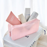 Pink cosmetic bag with skincare products on top of a book

#color_ballet pink twinkle