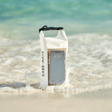 Phone case with a phone inside, partially submerged in water on a beach. #color_sand dollar
