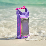 Purple and pink waterproof phone case with a phone inside, placed on a sandy beach with water in the background.
#color_purple paradise