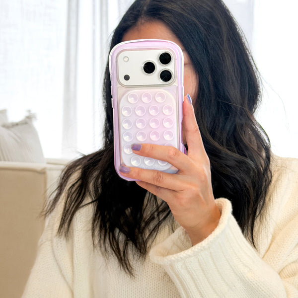 Person holding a phone with a bubble pop case in front of their face, wearing a white sweater. #color_iridescent