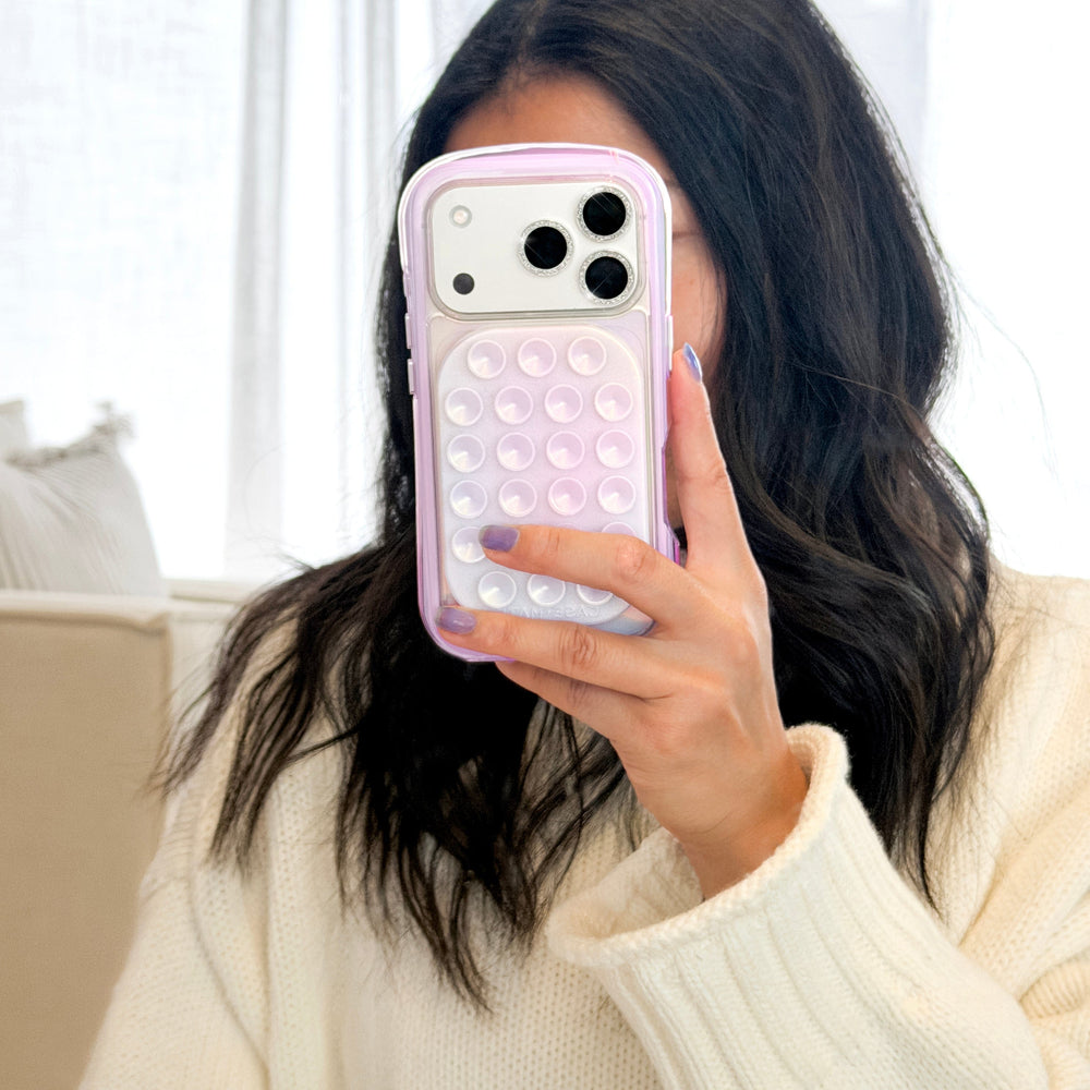 Person holding a phone with a bubble pop case in front of their face, wearing a white sweater. #color_iridescent