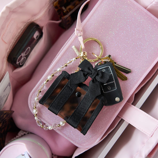 Keychain with black ribbons and gold accents on a pink surface
#color_tortoiseshell bow