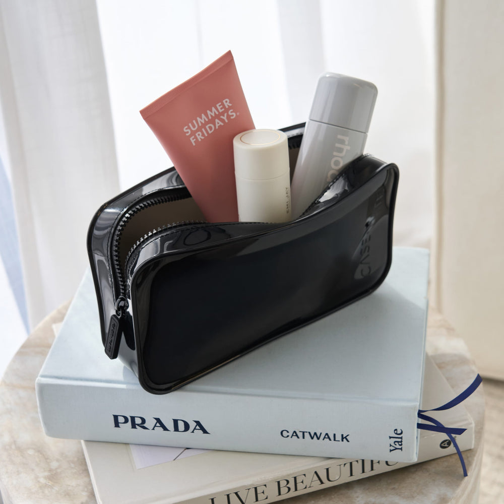 Black pouch with cosmetic items on top of a book