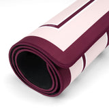A rolled-up exercise or yoga mat with a light pink and deep burgundy geometric pattern, showing a black textured interior lining, set against a clean white background.
#color_classic ballet pink