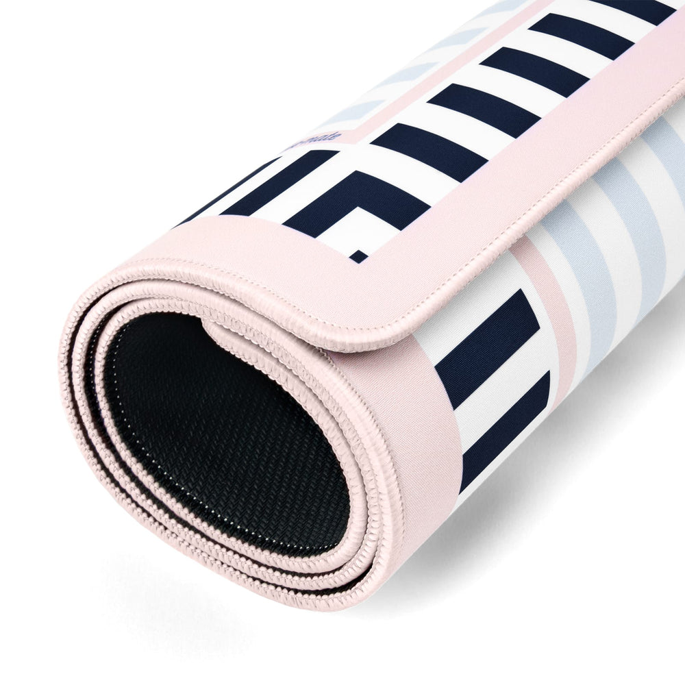 A rolled-up yoga mat featuring a geometric pattern in navy blue, white, and light pink, with a solid light pink underside and a black textured non-slip backing.
#color_classic cabana stripe